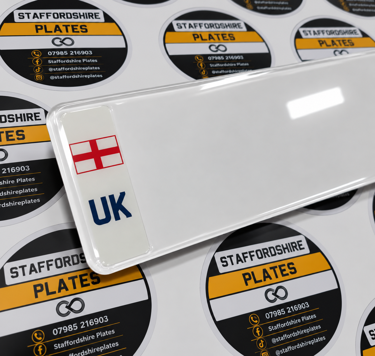 White number plate with a St George's flag and UK badge